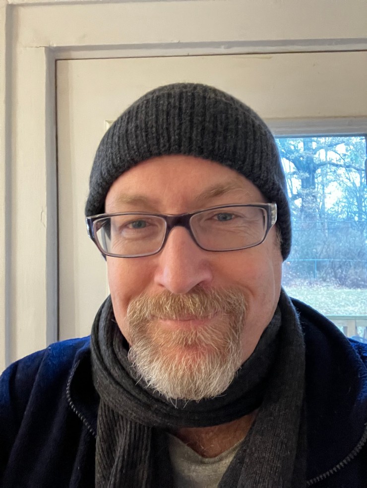 Bearded, bespectacled man in a winter hat